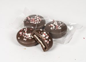 Chocolate covered oreos in a gift bag with crushed candy cane